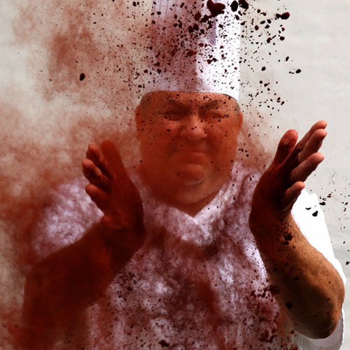 Photo of a chef throwing cocoa powder in the air