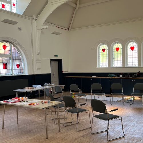 Century Hall - a hall with chairs and tables. There are windows with heart-shaped stained glass.